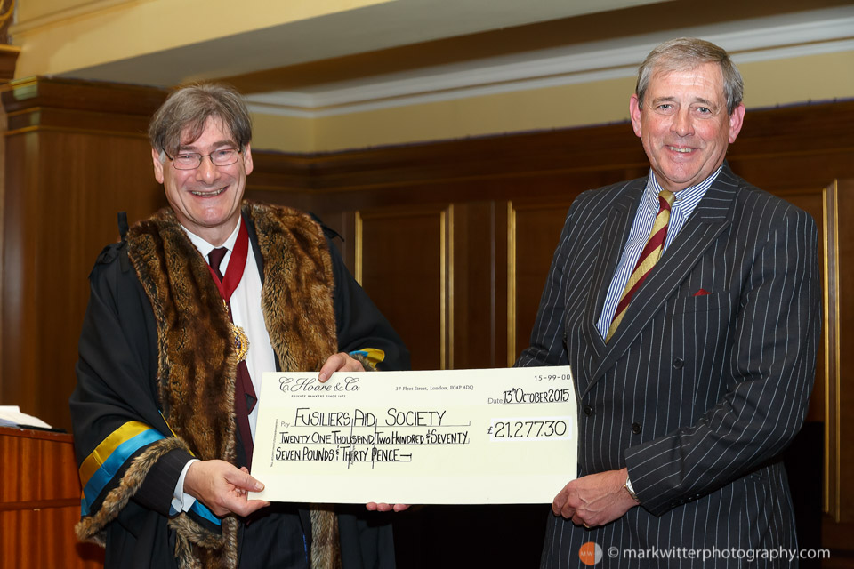 Colonel Nigel Easton QVRM TD of the Royal Fusiliers - (City of London Regiment) receives a cheque from John Rubinstein Master of the Cordwainers Company 2015 at the Cordwainers Fusiliers Dinner at the Clothworkers Hall.