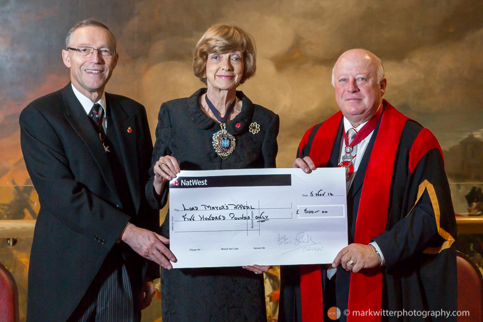 Dame Fiona Woolf DBE JP Lord Mayor of London 2013-14 receives a cheque at the Guildhall for the Lord Mayor's appeal from Colin Smith MBE BEM FIH Yeoman Warder at HM Tower of London and Chairman of the City of London Beadles' Guild 2014.